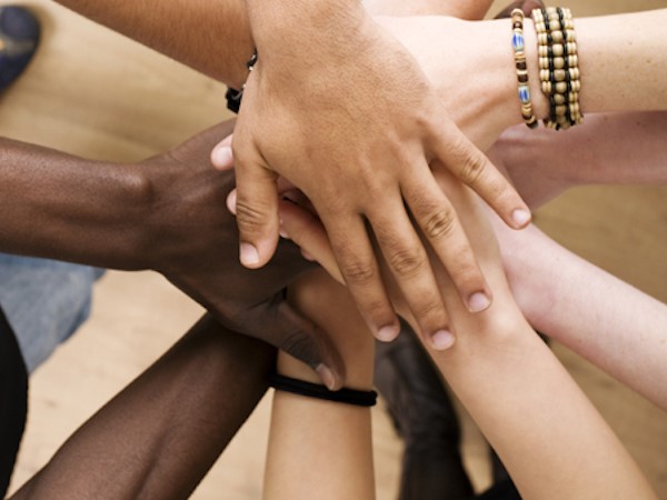 A diverse group of hands together in a circle
