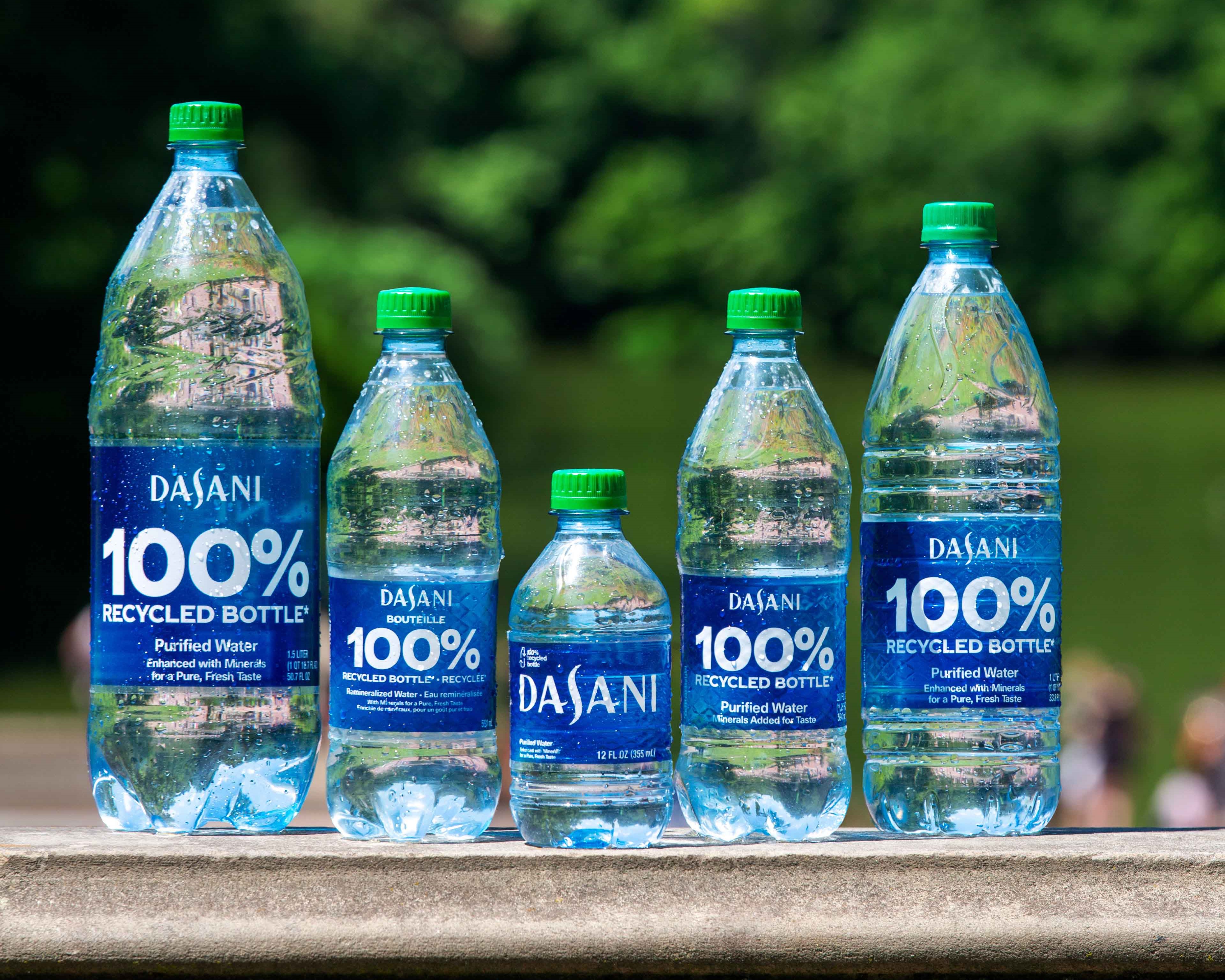 A lineup of different sized Dasani bottles made of 100% recycled plastic