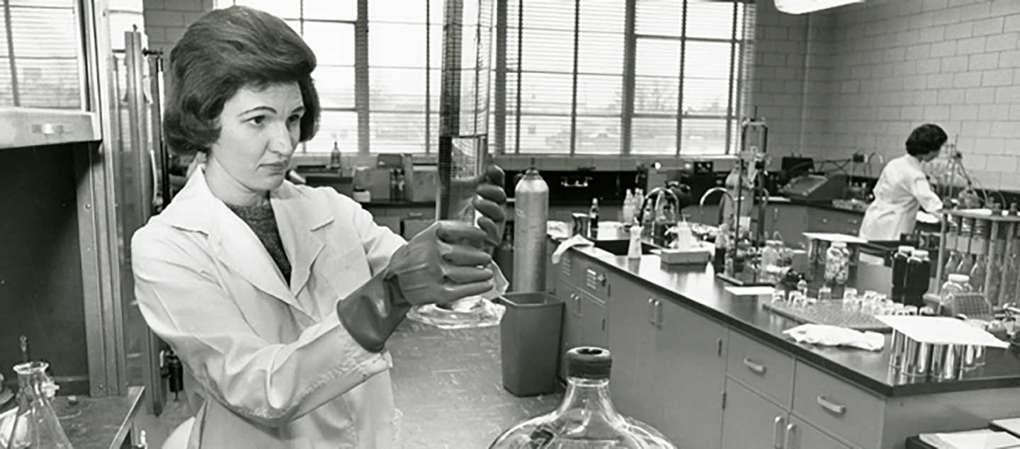 Black and white photo of woman working in Coca-Cola laboratory. 