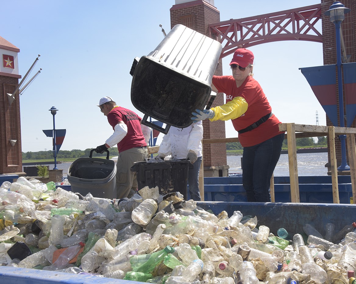 A woman and man empty recyclables into a large container in St Louis