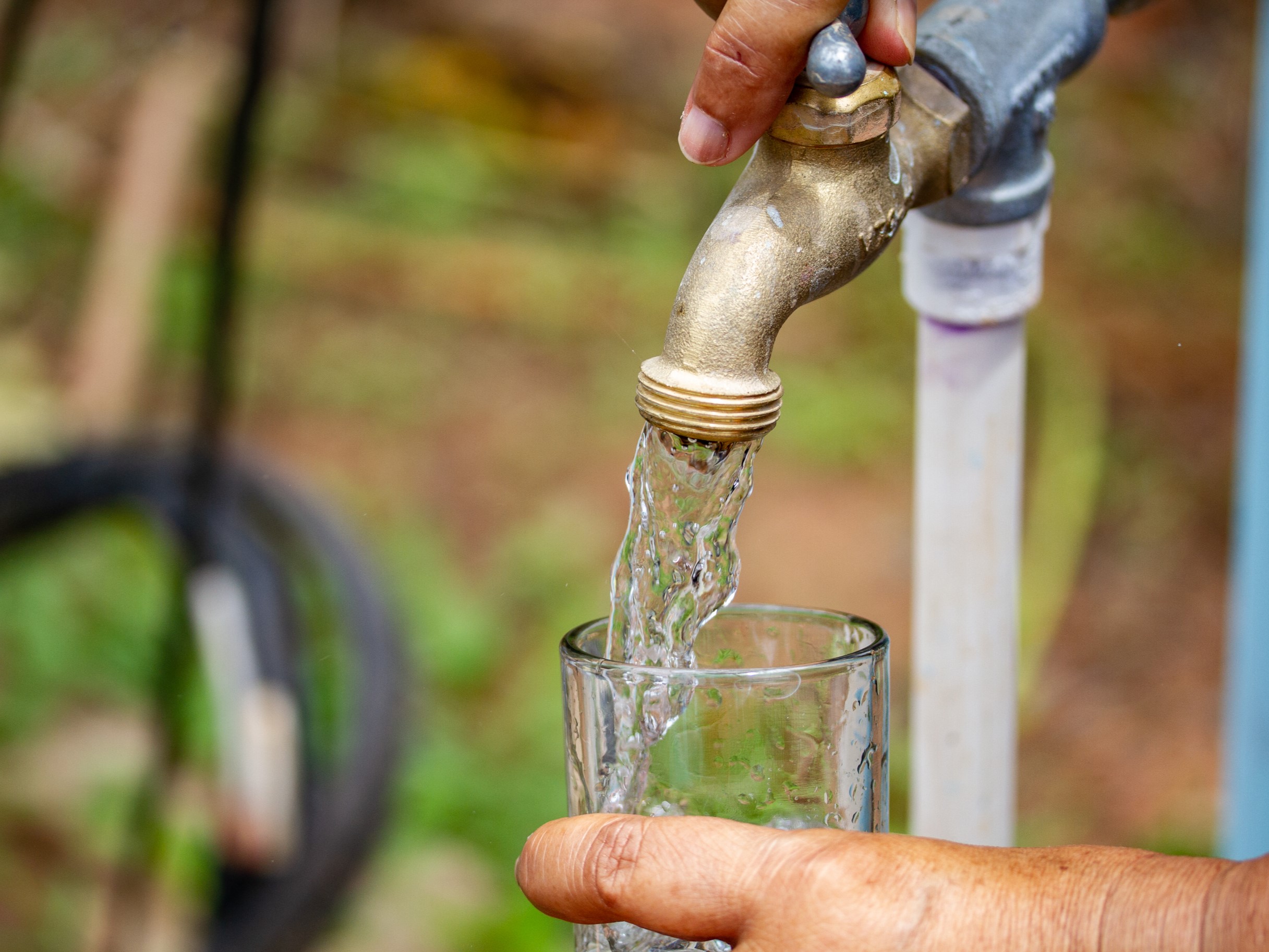Clean water pouring into a glass from an outdoor spigot