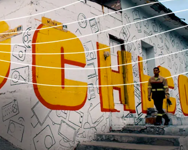 A man walks by Topo Chico wall art in Monterrey Mexico